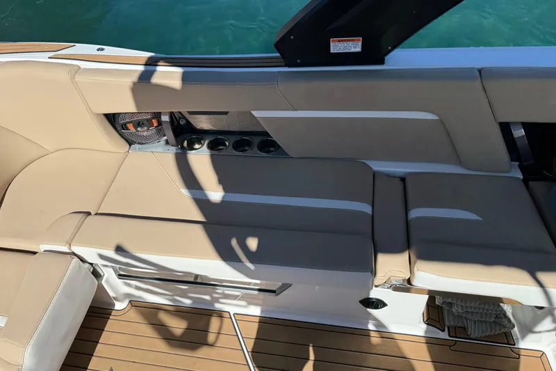 Slide: The Image of 2025 MasterCraft X24 boat interior with beige seating and cup holders. - 8
