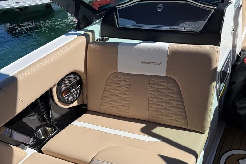 Slide: The Image of 2025 MasterCraft X24 boat interior with beige seating and integrated speaker. - 9