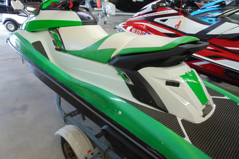Slide: The Image of 2014 Yamaha WaveRunner FX HO in green and white, parked indoors on a trailer. - 4