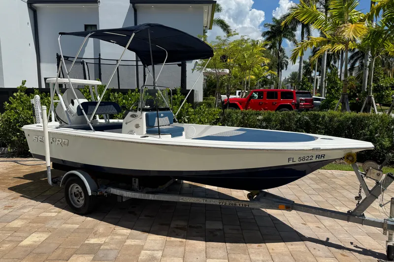 The Image of 2019 Sea Pro 172 Bay boat on trailer, parked outdoors with palm trees in background. - 0