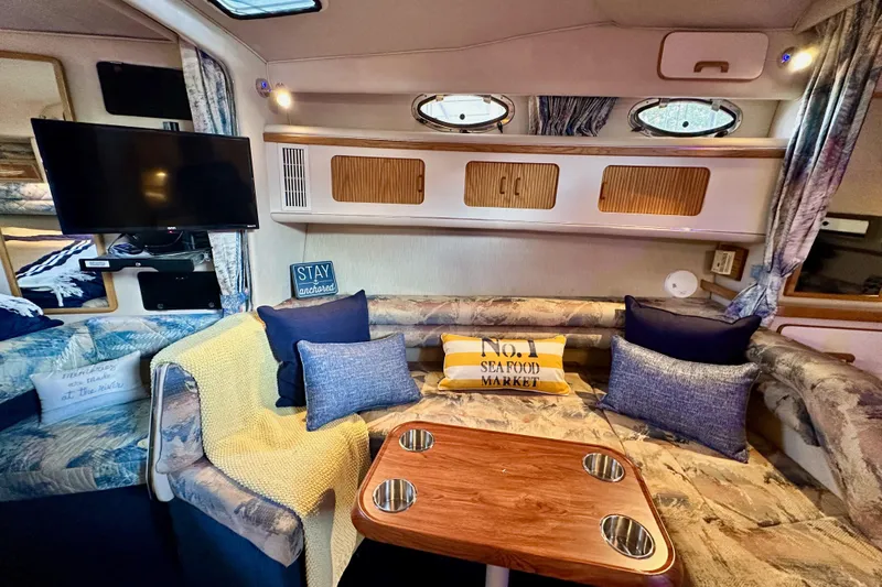 Slide: The Image of Interior of 1994 Sea Ray 330 Sundancer with cozy seating and nautical decor. - 10
