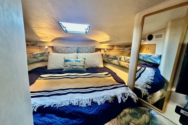Slide: The Image of Cozy cabin interior of 1994 Sea Ray 330 Sundancer with plush bedding and mirror. - 11