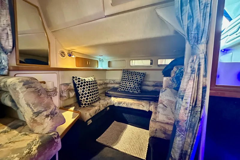 Slide: The Image of Interior of 1994 Sea Ray 330 Sundancer with cozy seating and patterned cushions. - 13