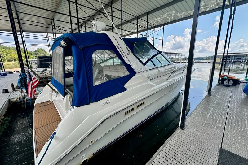 Slide: The Image of 1994 Sea Ray 330 Sundancer docked under a covered marina with blue canopy. - 2