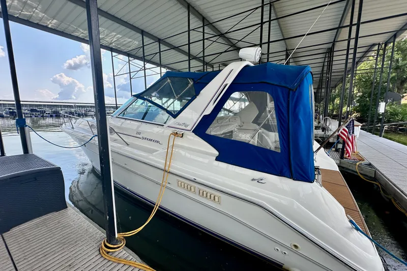 Slide: The Image of 1994 Sea Ray 330 Sundancer docked under covered marina with blue canopy. - 3