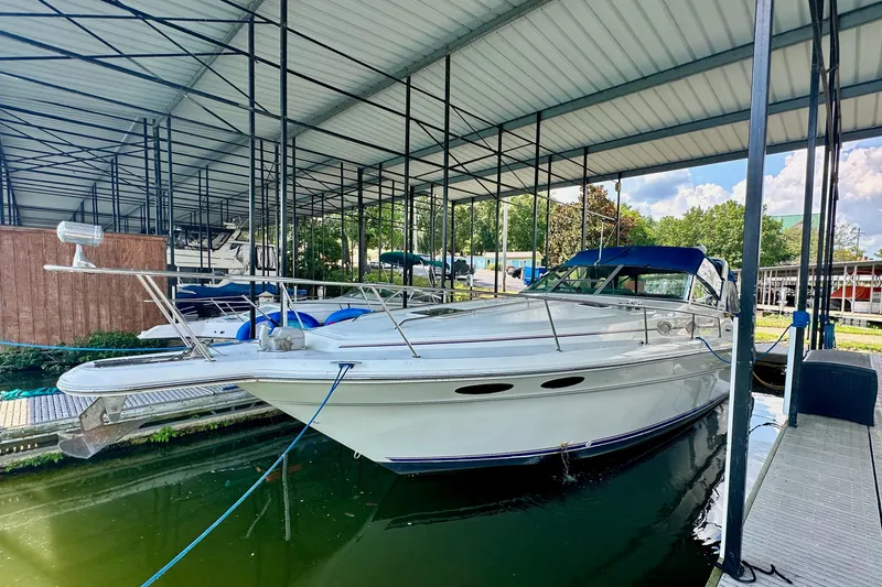 Slide: The Image of 1994 Sea Ray 330 Sundancer docked in a covered marina, featuring sleek white design. - 4