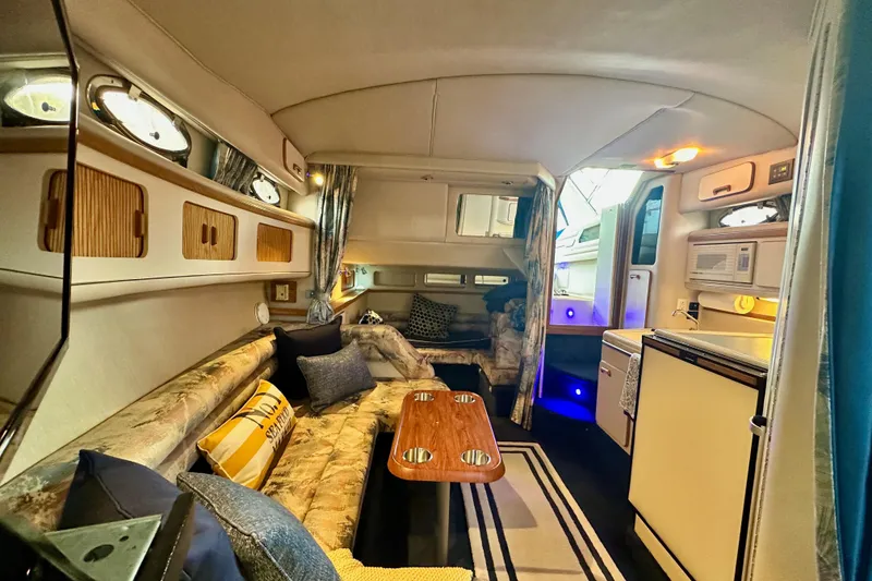 Slide: The Image of Interior of 1994 Sea Ray 330 Sundancer yacht with cozy seating and kitchenette. - 8