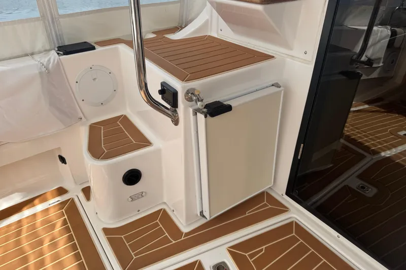 Slide: The Image of 2020 Cutwater C-30 CB boat interior with wood accents and compact fridge. - 10