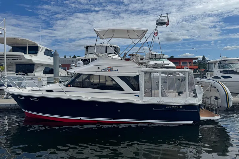 Slide: The Image of 2020 Cutwater C-30 CB boat docked at marina under blue sky. - 2