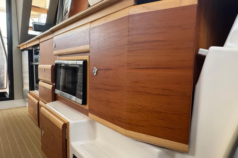 Slide: The Image of 2020 Cutwater C-30 CB interior kitchen with wooden cabinetry and built-in microwave. - 25