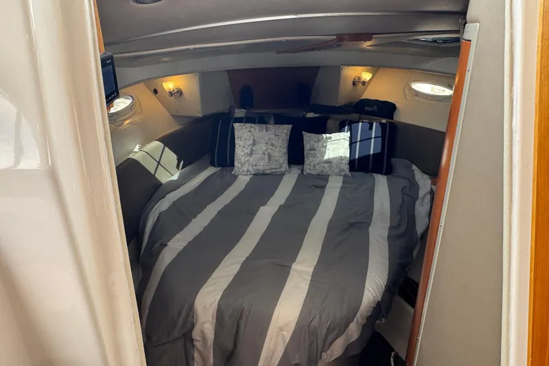 Slide: The Image of Cozy cabin interior of 2020 Cutwater C-30 CB with striped bedding and decorative pillows. - 26