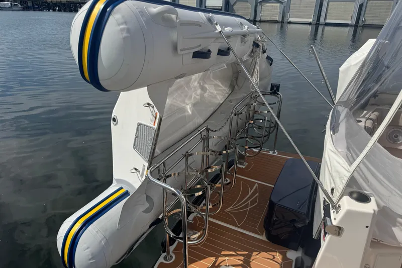 Slide: The Image of 2020 Cutwater C-30 CB boat with inflatable dinghy on deck, docked by the water. - 7