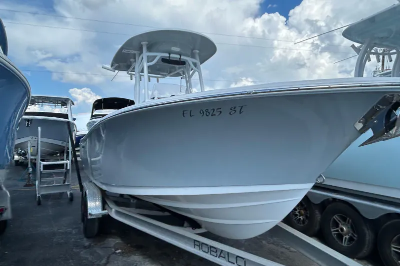 The Image of 2021 Sportsman Open 232 Center Console boat on trailer under cloudy sky. - 0