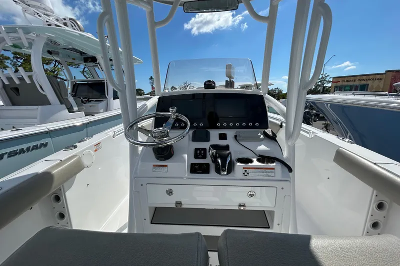Slide: The Image of 2021 Sportsman Open 232 Center Console boat interior with steering wheel and control panel. - 10