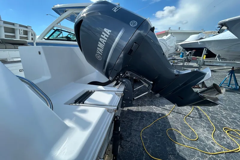 Slide: The Image of 2021 Sportsman Open 232 Center Console with Yamaha outboard motor, docked under clear sky. - 4