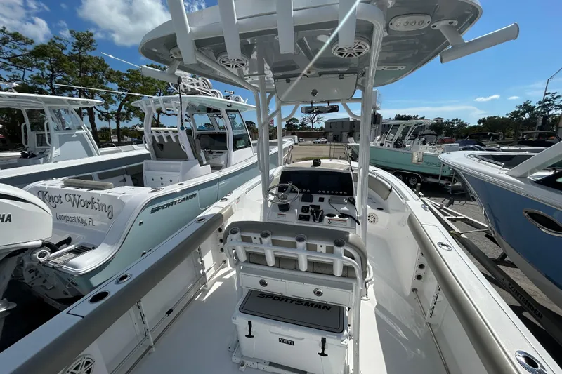 Slide: The Image of 2021 Sportsman Open 232 Center Console boat, sleek design, docked under clear blue sky. - 9