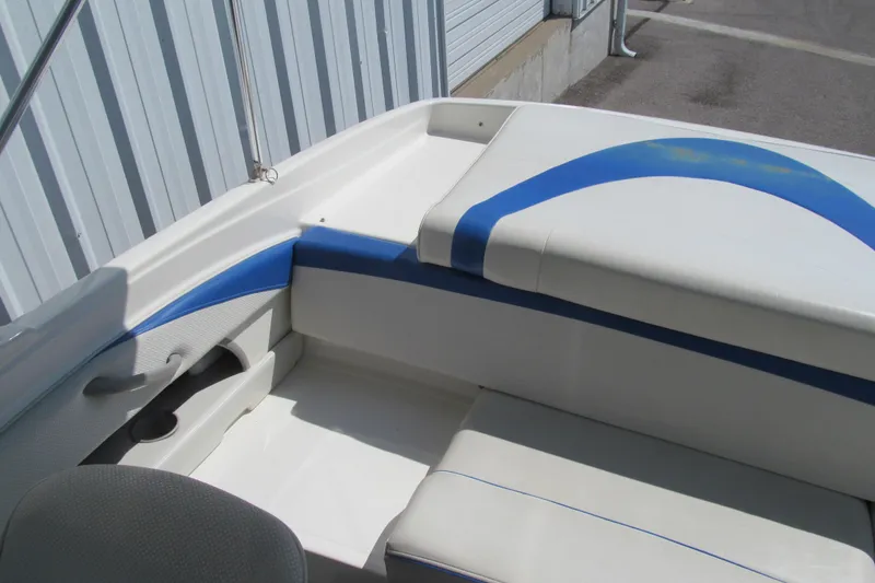 Slide: The Image of 2007 Bayliner 185 boat interior with blue and white seating. - 12
