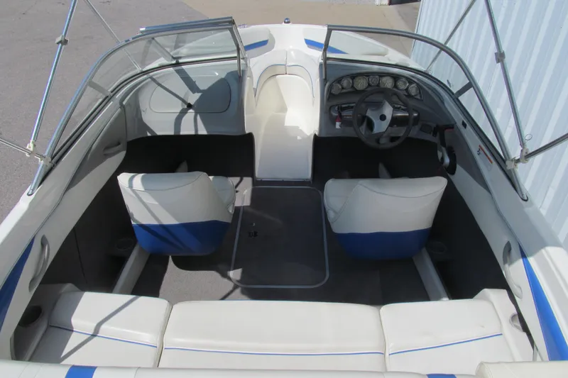 Slide: The Image of 2007 Bayliner 185 boat interior with white and blue seating, steering wheel, and dashboard. - 5