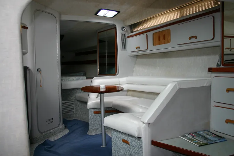 Slide: The Image of Interior of a 1991 Sea Ray 310/330 Sundancer yacht with white seating and wooden accents. - 15