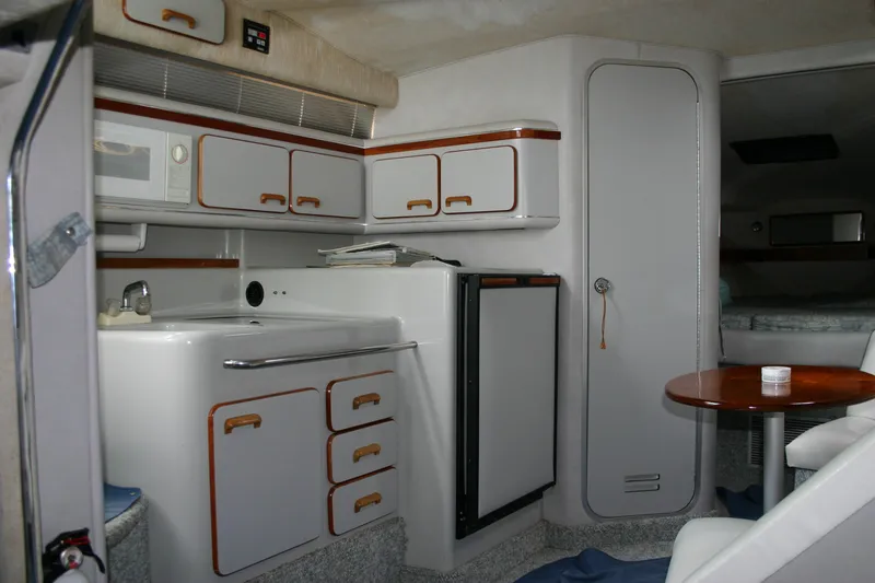 Slide: The Image of 1991 Sea Ray 310/330 Sundancer interior with kitchenette and seating area. - 16