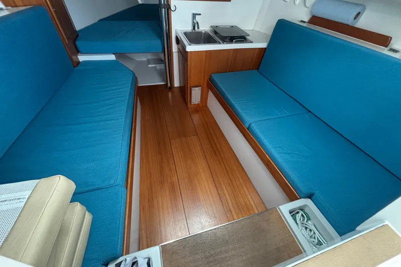 Slide: The Image of 2019 Saffier Sc 8.0m Cabin interior with blue seating and compact kitchenette. - 16