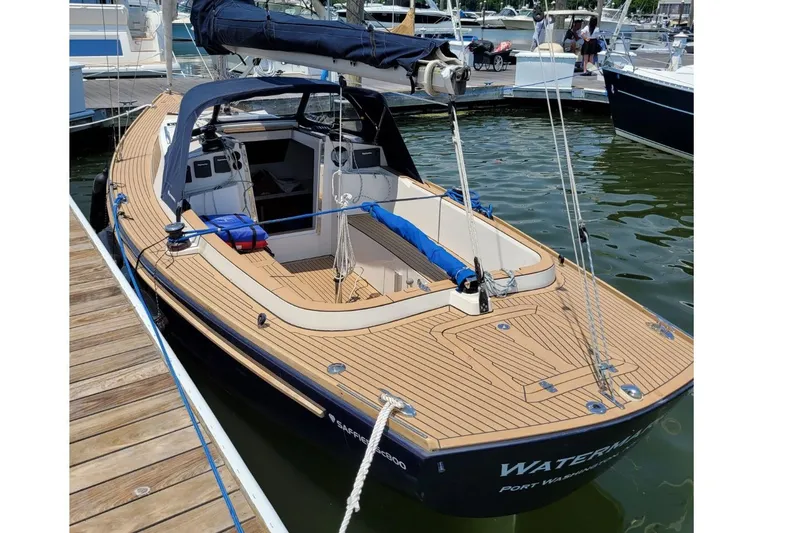 Slide: The Image of 2019 Saffier Sc 8.0m Cabin sailboat docked at marina, featuring sleek wooden deck. - 2