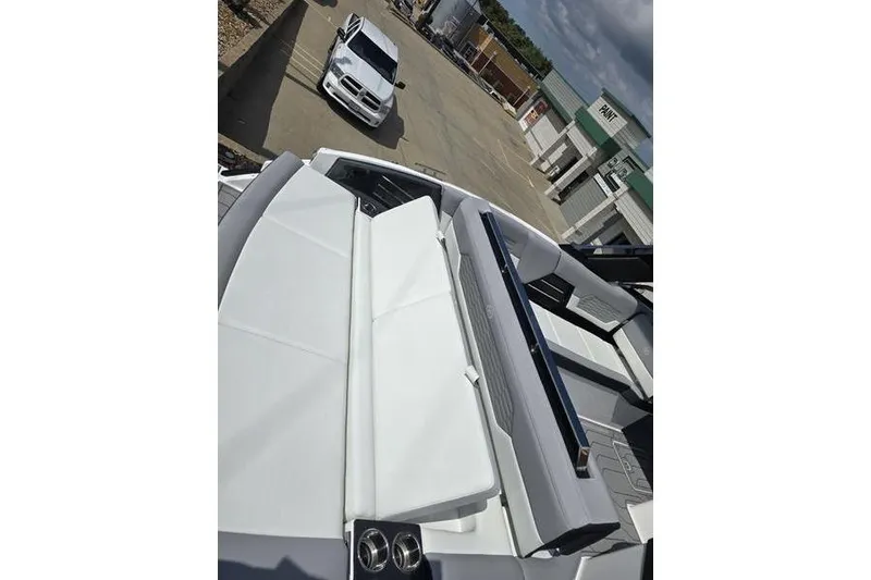 Slide: The Image of 2026 Cobalt A29 boat with sleek white seating, parked near a white car. - 14