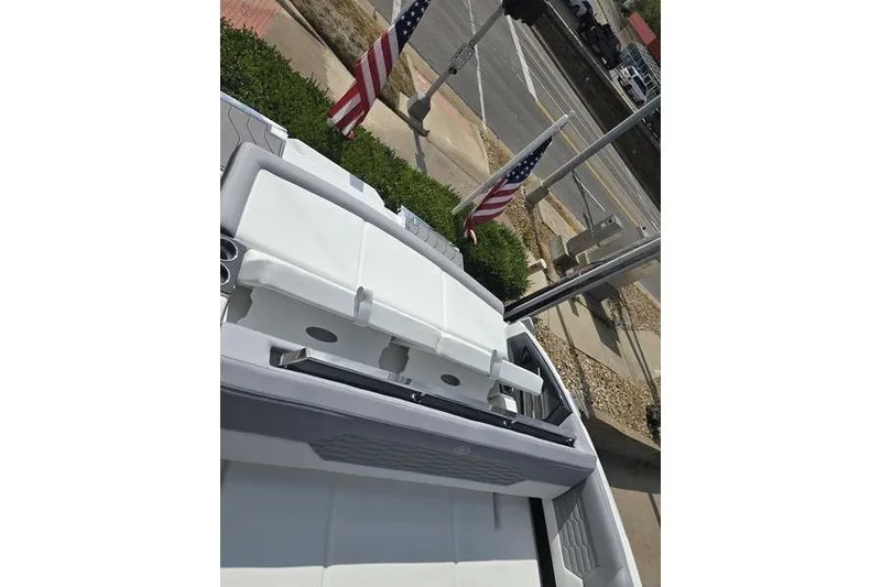 Slide: The Image of 2026 Cobalt A29 boat interior with white seating, American flags in the background. - 2