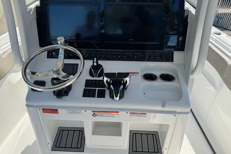 Slide: The Image of 2025 Sea Hunt Ultra 305 SE boat dashboard with steering wheel and control panels. - 12