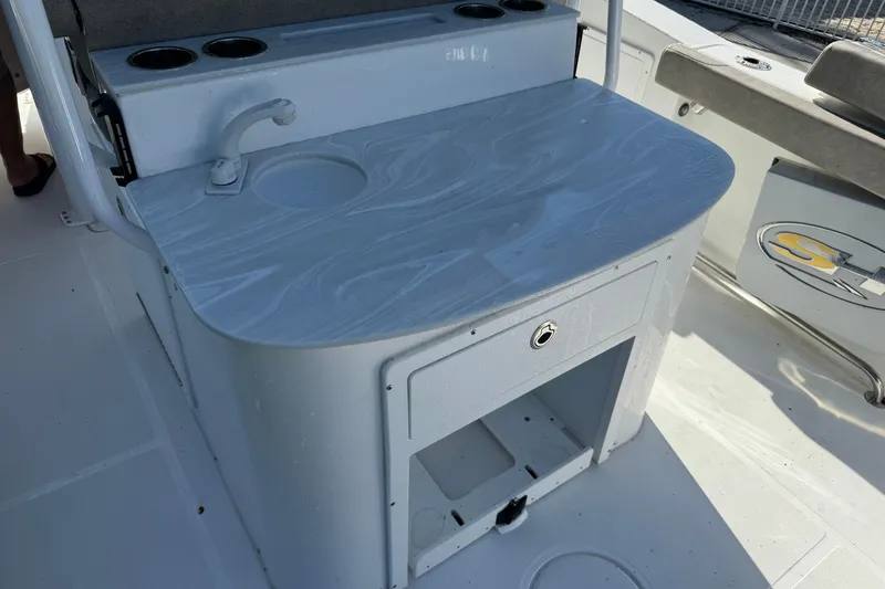 Slide: The Image of 2025 Sea Hunt Ultra 305 SE boat interior with sink and storage area. - 13