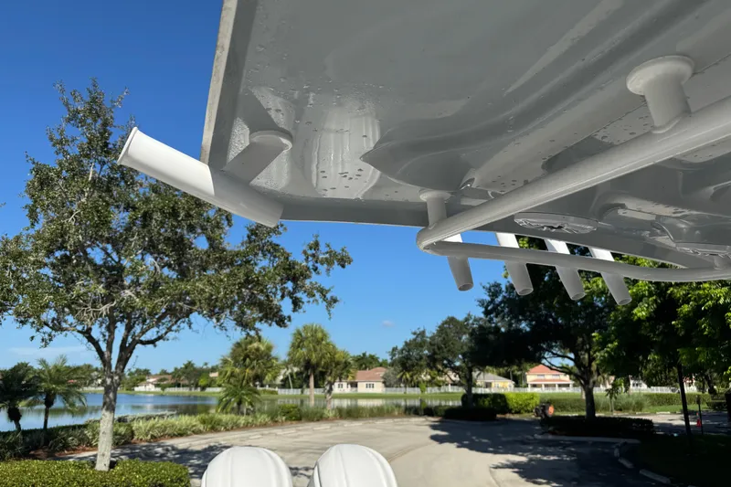 Slide: The Image of 2025 Sea Hunt Ultra 305 SE boat detail with rod holders, scenic lake view in background. - 15