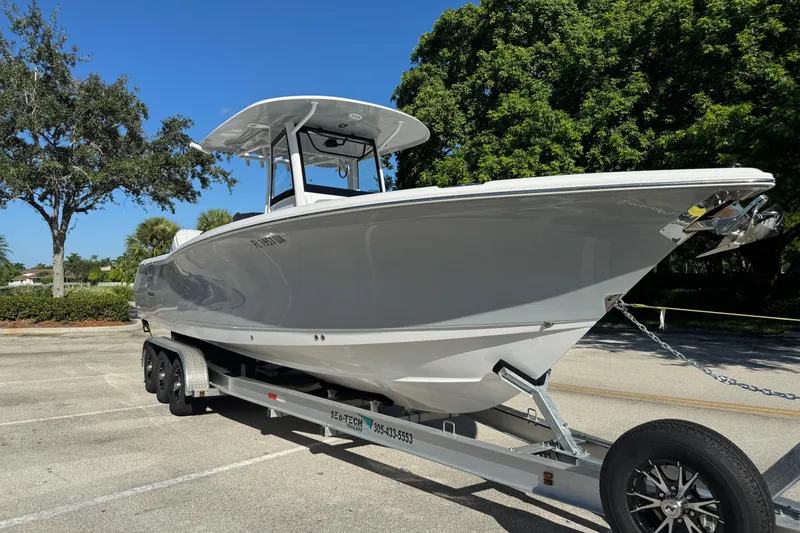 Slide: The Image of 2025 Sea Hunt Ultra 305 SE boat on trailer, parked outdoors under clear blue sky. - 3