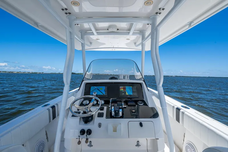 Slide: The Image of 2010 Intrepid 323 OPEN boat dashboard with ocean view, featuring navigation equipment. - 12
