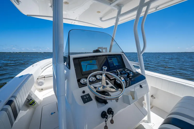 Slide: The Image of 2010 Intrepid 323 OPEN boat dashboard with ocean view, featuring modern navigation equipment. - 13