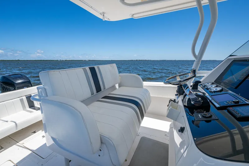 Slide: The Image of 2010 Intrepid 323 OPEN boat interior with helm, seating, and ocean view. - 16