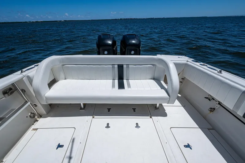 Slide: The Image of 2010 Intrepid 323 OPEN boat with white seating, dual engines, and ocean backdrop. - 20