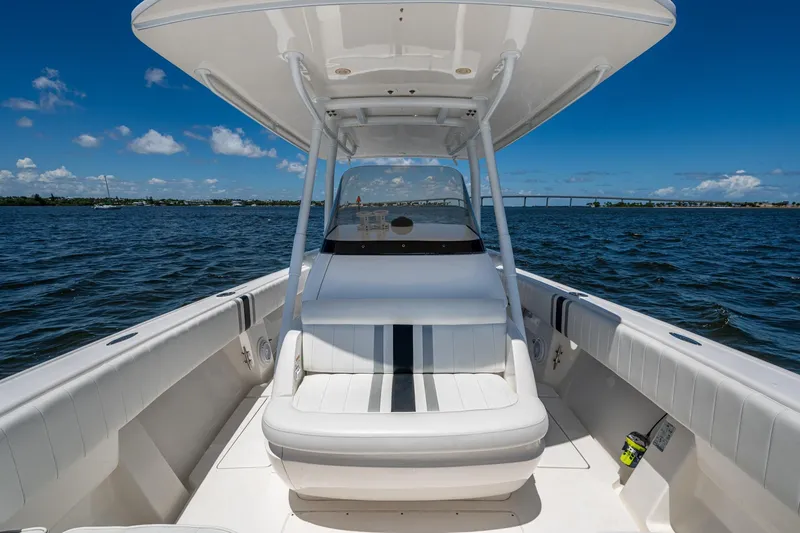 Slide: The Image of 2010 Intrepid 323 OPEN boat on water, clear sky, spacious seating, sleek design. - 21