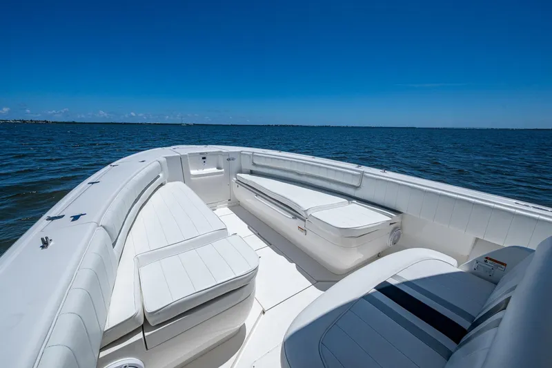 Slide: The Image of 2010 Intrepid 323 OPEN boat interior with white seating, on calm blue water. - 26