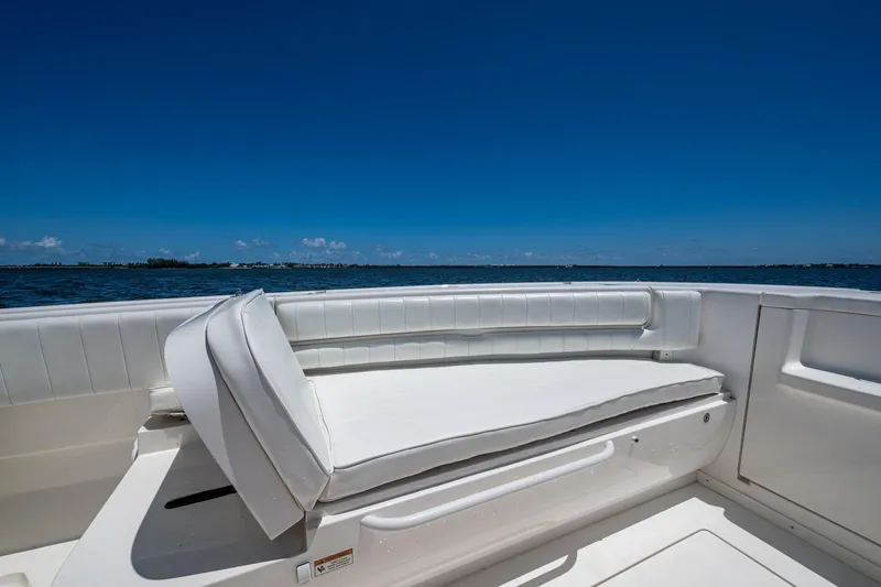Slide: The Image of 2010 Intrepid 323 OPEN boat interior with white seating, ocean view, clear blue sky. - 28