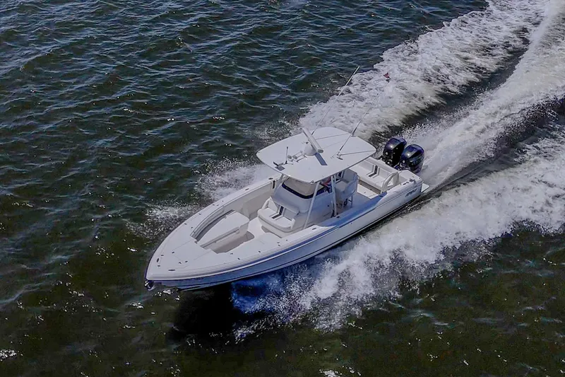 Slide: The Image of 2010 Intrepid 323 OPEN boat cruising on open water, creating a dynamic wake. - 3