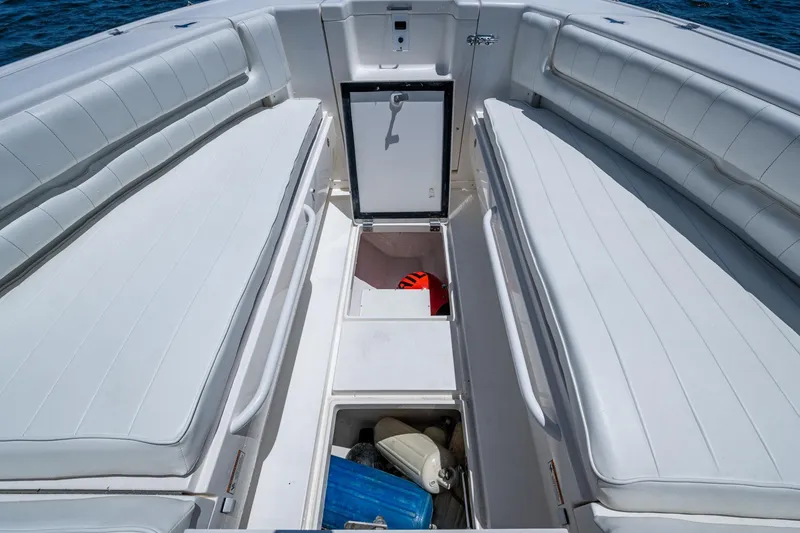 Slide: The Image of 2010 Intrepid 323 OPEN boat interior with white seating and storage compartments. - 30