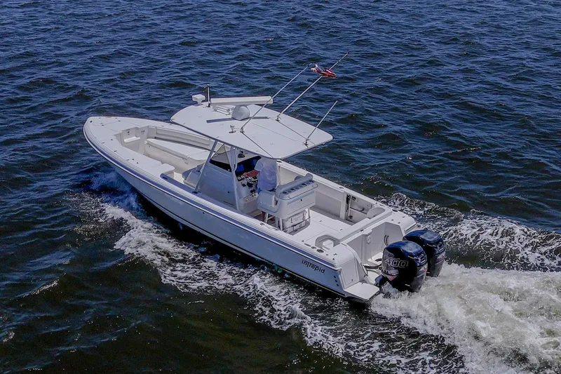 Slide: The Image of 2010 Intrepid 323 OPEN boat cruising on open water, featuring dual outboard engines. - 5