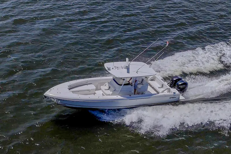 Slide: The Image of 2010 Intrepid 323 OPEN boat cruising on open water, creating waves. - 6