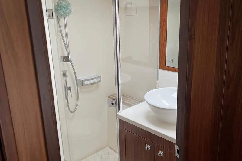 Slide: The Image of Luxurious bathroom in 2020 Riviera 4800 Sport Yacht with modern fixtures and wooden accents. - 13