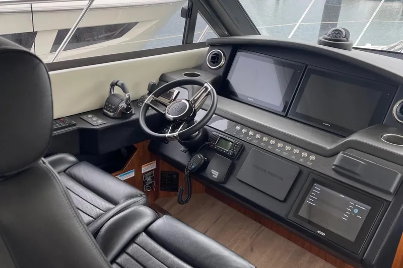 Slide: The Image of 2020 Riviera 4800 Sport Yacht helm with modern controls and leather seating. - 3