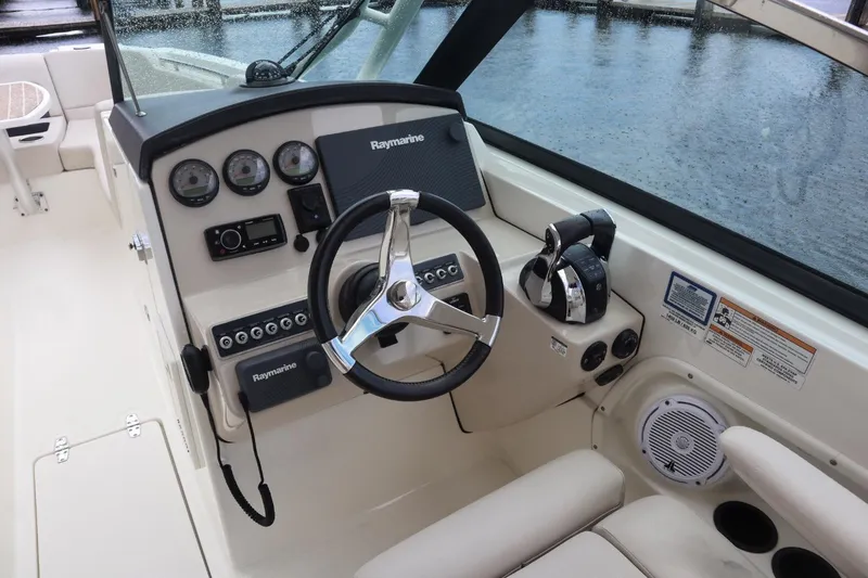 Slide: The Image of 2017 Boston Whaler 270 Vantage boat dashboard with Raymarine electronics and steering wheel. - 11