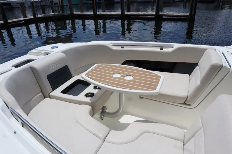 Slide: The Image of 2017 Boston Whaler 270 Vantage boat interior with seating and table, dockside view. - 13