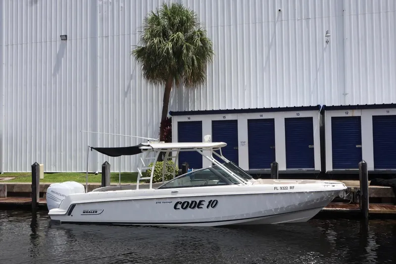 Slide: The Image of 2017 Boston Whaler 270 Vantage boat docked near storage units. - 16
