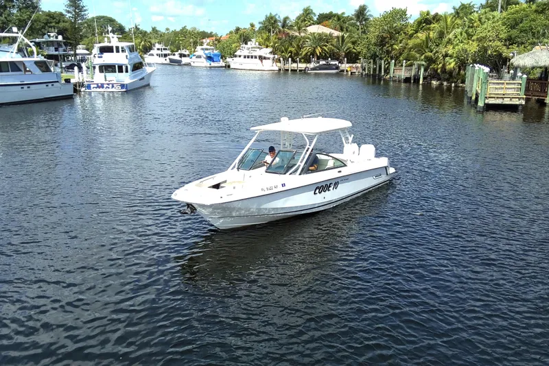 Slide: The Image of 2017 Boston Whaler 270 Vantage boat cruising on a scenic waterway with lush surroundings. - 2