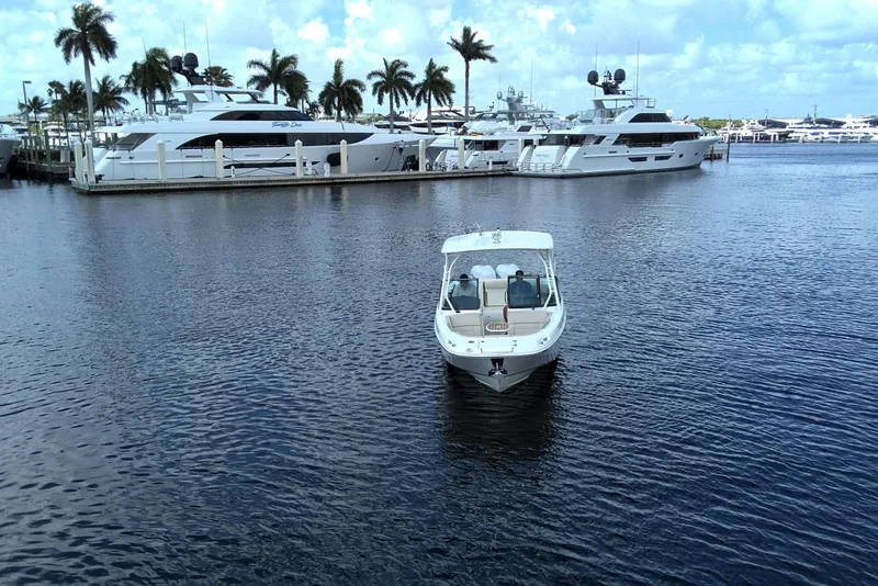 Slide: The Image of 2017 Boston Whaler 270 Vantage boat on calm water near luxury yachts and palm trees. - 3
